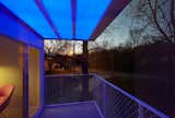 A balcony makes the most of the home's sloping site, offering views of the nearby forest and even faraway mountains.  Photo 6 of 6 in This Illuminated Arkansas Home Changes Colors with the Tap of a Smartphone by Luke Hopping
