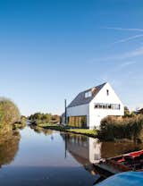 Exterior, Gable RoofLine, Shingles Roof Material, and House Building Type The newly built house, just feet from the water’s edge, occupies the space where a decaying farmhouse once stood.  Photo 4 of 7 in Daring Dutch Homes by Luke Hopping from A Modern Take on the Pitched-Roof