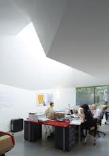 The side entrance to the office space lies in a sunken courtyard, which required backyard excavation (and a sign-off from a horticulturist to guarantee the digging didn’t interfere with a walnut tree). The abstract geometry of the extension allows for unique openings and a skylight that provides natural light to the staff throughout the day.&nbsp;