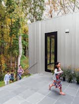 Exterior, House Building Type, Metal Siding Material, and Flat RoofLine The flooring in the house alternates between seven-inch-wide oak planks and slate tile, the latter extending to the first-floor terrace.  Photo 3 of 13 in Ways to Use Slate in the Home by Andrea Smith from This Woodland Home in Virginia Was Built for Modern, Multigenerational Living