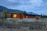 The house is divided in two: on the left, the main house consists of an expansive kitchen, living, and dining space, plus sleeping accommodations. On the right, a smaller structure holds a sauna, shower, and ski wax room. The house’s length is oriented along an east/west axis to maximize strong southern light and provide views of an aspen grove.  Photo 1 of 7 in Modern Mountain Retreat in Washington by Zach Edelson