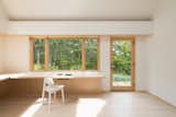 Present Architects relied on warm-toned materials for the addition, using white birch for the cantilevered desk and white stained oak for the floors. The warm palette not only makes for a calm, open interior space, but provides context for the rest of the house.