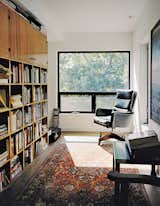 In homeowner Bill Mathesius’s office on the third floor, an antique armchair, a rug, and a bookshelf made from salvaged wood create a cozy, sun-filled reading nook.