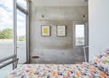 The raw concrete panels serve as a backdrop for the couple’s design collection. The bedroom features a Rocking Stool by Isamu Noguchi for Knoll and a Kelvin lamp by Antonio Citterio for Flos.  Photo 9 of 9 in In Just 48 Hours, a Chicago Live/Work Space Is Built from the Ground Up Using Concrete Panels