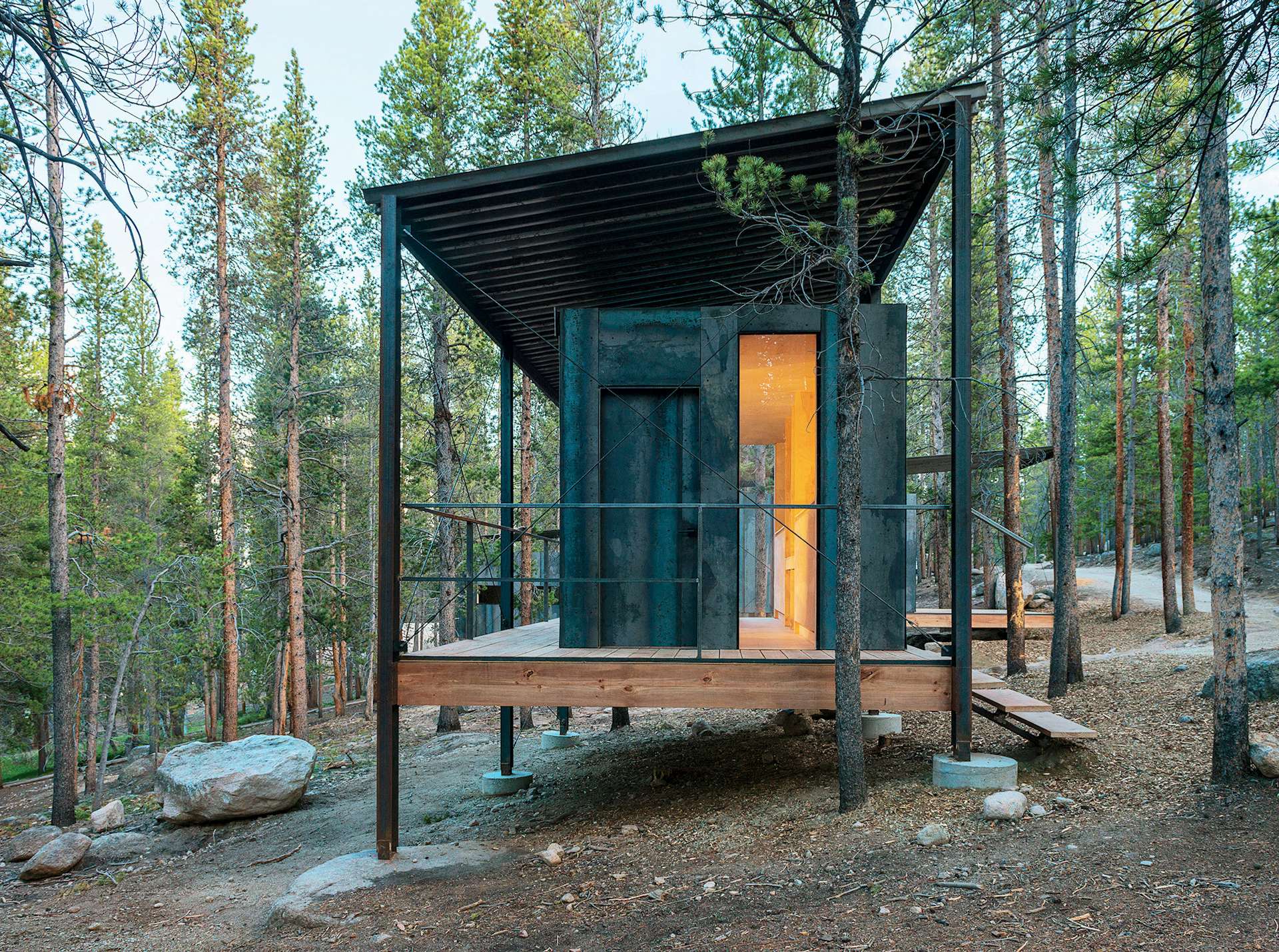 The Outward Bound cabins, designed by the University of Colorado Denver's design-build program, have steel frames that lift the structures above a three-foot snowpack while supporting corrugated-steel 