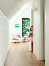 Kids Room and Bedroom Room Type The second floor holds three bedrooms and a living area for the girls. Here, Paula, 11, and Sofia, 9, hang out near an IKEA PS 2012 sofa by Nike Karlsson. The slatted wall at left allows a view to the downstairs.  Photo 7 of 12 in This Bright Green Prefab in Sweden Looks Just Like a Monopoly House