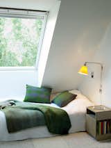 Bedroom and Bed Upstairs, each daughter’s bedroom was designed as a sanctuary, with cozy touches like Simon Key Bertman quilts and cushions. The bed and Pile bedside table by Jessica Signell Knutsson sit on top of a Carpet Honeycomb by designer Maria Löw.  Photo 5 of 10 in d w e l l by Courtney from This Bright Green Prefab in Sweden Looks Just Like a Monopoly House