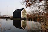 The Island House sits on a petite man-made island in 'Loosdrechtse Plas,’ a lake area near Amsterdam and Breukelen (from which the New York borough gots its name). The thin strip of land, a result of peat farming centuries ago, inspired the design of the cabin.