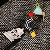You can snap up a limited selection of brooches, necklaces, and earrings from the Acme Studio Memphis collection at SHOP Cooper Hewitt, like ceramist Natalie Herrera (aka @fromhighgloss on Instagram) did. Shown here are the Monumento brooch by Ettore Sottsass, left, and Oreliana brooch by Marco Zanini, left.
