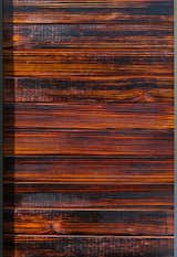 The charred-wood siding, inspired by shou sugi ban, comes in various stains, such as cherry (shown here). The blow-torching technique helps with resistance against insects, rot, water, mold, and fire.