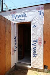 Dupont Tyvek weather barrier covers the wall near a doorway. Tyvek flashing will be added prior to the door installation.