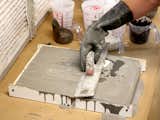 Because the edge of the slab is exposed, Howe uses a trowel to work the pigment all the way through.
