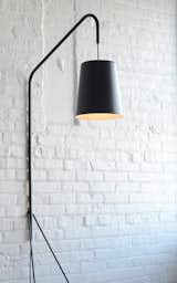 The rubber-dipped steel base, aluminum neck, and spun shade keep the Eileen lamp ($1,200) balanced when leaning against a wall or in a corner.