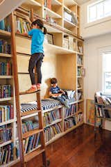 A former 

closet was transformed into a double-height library, complete with a reading nook and a rolling ladder from Spiral 

Stairs of America. “That’s my 

favorite part of the house,” says Dan. 

“When I see Stella reaching for a book, 

there’s nothing better.”