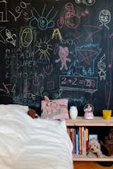 Two small kids rooms sit next to one another on the other side of the kitchen from the master suite. In this one, for the owner's daughter, chalkboard paint jazzes up a modest interior.