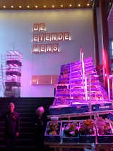 The grand entrance to De Etende Mens shows the Aquaponics system and indoor farming setup with distinct blue-red lighting elements.