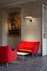 Two bright red Poet sofas face off in the vestibule leading into "Furniture for the Senses." Juhl designed the sofas in 1941 for use in his own home (more on that to come!).  Photo 3 of 11 in Finn Juhl Centennial at Designmuseum Danmark by Kelsey Keith