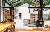 Dining Room, Storage, Chair, Standard Layout Fireplace, Wood Burning Fireplace, and Table The “tiny but mighty” structure—as Grizzle describes it—packs a wealth of uses into a compact footprint.  Search “wall bookshelf” from This Renovated Garage is the Ultimate Modern Party Space