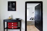 A black side table rests outside the bedroom hallway.  Photo 7 of 12 in Modern Meets Traditional in a Swedish Summer House