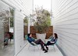 Outdoor, Small Patio, Porch, Deck, and Concrete Patio, Porch, Deck Shannon and his wife, Amy, take the air on a small patio in two Acapulco chairs.  Photo 9 of 15 in Row on 25th: Affordable Housing Development in Houston