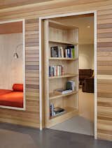 With a gentle push, the bookshelf swings open on hinges to reveal a secret media room.