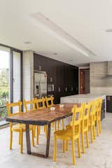 The custom kitchen counters are concrete, and the yellow dining chairs add a welcome splash of color.