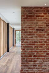 Hallway and Medium Hardwood Floor Burneo added exposed brick to his palette of interior materials.  Photo 6 of 7 in Uncle Knows Best