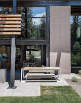 A picnic table from Janus et Cie sits off the kitchen; the landscape architecture is by Richard D. Wood. In addition to passive solar, says Hawkins, “there is the added benefit of a thick concrete slab as a thermal mass that absorbs and stores the heat from the sun.”