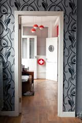 View into the bedroom with private terrace from the living room. A simple palette of grays blend with the industrial chic aesthetic, with splashes of red and gold.