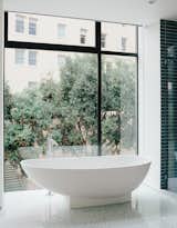 The bathroom features a tub by Benedini Associati for Agape, Dornbracht tub filler, and retractable shades.