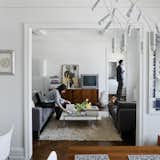 White lighting elements, finishes, furnishings, walls, and moldings create a feeling of modern openness to this traditional floor plan in New York. Architect Stephan Cassell helped the transplanted couple see past the "43 layers of paint" to the modern potential within. “These old buildings always have interesting layouts that work well,” Cassell notes, “and have a certain elegance to them." See the transformation.