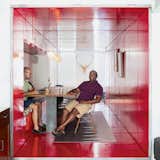By inserting a tunnel made from 36 reclaimed commercial doors and tearing down a handful of walls, LOT-EK and contractor Andreas Scholtz brought light into the formerly unused dark hallway in Maurice Russell (right) and Jorge Fontanez’s apartment. The glossy Safety Red paint by Benjamin Moore catches the light by day but “becomes a richer, darker, very relaxing red at night,” Fontanez says.