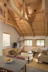 The redesign opened up the ceiling to reveal historic but damaged trusses, which were rehabilitated or replaced with Douglas fir depending on their degree of rot. The sofa and side tables below are from Mitchell Gold + Bob Williams. The desk chair is from McGuire.  Photo 1 of 40 in 40+ Homes With Exposed Beams: Rustic to Modern by Luke Hopping from A Small Loft Sits Above a Renovated Barn in California
