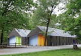 The two-tone corrugated metal cladding helps these Kansas City camping sheds blend into the landscape, along with windows custom-colored by the manufacturer to match.