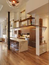 BSC designed suspended powder-coated and walnut open shelves to demarcate the kitchen from the rest of the living space. The detailing on the cast-iron columns inspired the perforated pattern of the semi-transparent screens.