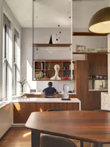 The open shelving reaches to the apartment’s 13-foot ceilings, bringing the eye’s attention upwards. Built-in furniture, like the desk Bart works at, was designed throughout the apartment. The couple imagine the desk will be taken over by their children once they’re old enough to do homework. “The design of the space allows us to spend time together, even when we’re doing different things,” Bart says, of the open floor plan.