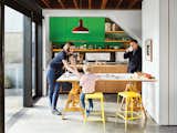 Artist Stephen Waddell and wife Isabel Kunigk—a landscape designer—remodeled their 1,300-square-foot bungalow with a raised roof and a kitchen that opens up to the living room. The apple-green cabinets were made by Waddell and a friend, and yellow stools add a playful touch.&nbsp;