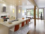 Kitchen, Wood Cabinet, Engineered Quartz Counter, Light Hardwood Floor, and Pendant Lighting The kitchen is outfitted with a duel-fuel range by Bosch, a Diamonte Canopy hood by Faber, a LaPerla dishwasher by Miele, French-door refrigerator by LG, Blanco sink, and Compact Smart overn by Breville. Catifa 46 stools by Arper are stationed at the bar. The counters are quartz and the cabinets are solid maple. "Given that the owners’ intention was to stay and age in the house, we decided that the materials needed to be elegant and timeless and, in essence, could also age well in place," Tedesco says. "This led to devising a refined and warm palette of natural finishes. White carrara marble, oiled clear Douglas fir, and maple floors and millwork create a light, warm interior with a reddish hue that emanates when the sunlight washes the woods. The selection process included R-and-D on the materials to assess their ability to be both robust enough to handle every day wear and tear in the short term and acquire a beautiful patina long term. We also researched MSDS charts to ensure they were safe, non-toxic, and would not off-gas."  Search “artek rocket stool red” from Smart Tech Makes this Modern Home Ultra Energy Efficient