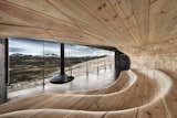 The Norwegian Wild Reindeer Pavilion by SNØHETTA offers visitors a perch to watch wild reindeer herds in the mountains of central Norway. It features a smooth wood ampitheater and a wood-burning stove.  Photo 8 of 9 in Truly Imaginative Buildings Around the World by Allie Weiss