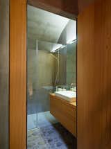 Custom case work and a polished wall give the bathroom a warm yet minimal look.
