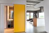 Canary yellow doors keep the house from feeling austere. The sliding function also saves space.