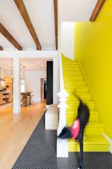 Staircase, Wood Tread, and Wood Railing "I always wanted to have my very own yellow brick road," says Viviana de Loera, whose favorite part of the home is the playful staircase. The original stairs and handrail were preserved in the renovation.  Search “minimal metal clad montreal house hidden courtyard” from How to Decorate With Yellow (Without the Smiley-Face Connotations)