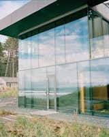 Exterior, Flat RoofLine, House Building Type, and Glass Siding Material Architects Stan Boles and Christopher Almeida arranged ten-foot-tall panes of glass in a steel curtain-wall frame to create the building’s distinctive facade.  Photo 3 of 9 in Glass House with Stunning Pacific Ocean Views
