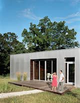 The front deck, invisible from the road, is an extension of the wood paneling in the main living space.