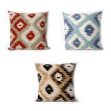 A trio of Manné's Ikat Diamonds pillows. From clockwise: Aqua, Black, and Red.  Search “professor acorn pillow” from A Chat with Designer Liora Manné