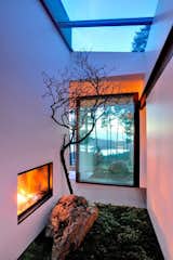 A mini landscape nook plays neighbor to the enclosed fireplace inside this hillside home on Orcas Island, Washington. Via Trendir. (Pin)