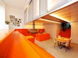 Parksite Residence-A former ambulance garage turned into a home by carving out a dugout for the kitchen and dining area. The surrounding orange steps function as seating while the polycarbonate “lightbox” creates a second story used for the bedrooms.  Photo 3 of 7 in Slammin’ Scandinavian Interiors by Olivia Martin