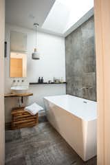 In the bathroom, the sink is mounted on salvaged live-edge wood.