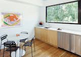Dining Room, Table, Chair, and Light Hardwood Floor LABhaus designed the custom cabinetry for the mini-kitchen in the great room; the articulated faucet is by Kohler.  Photo 4 of 11 in Cute Couple Alert: Modern Prefab Poolhouse Addition to a 1920s Sears Kit House