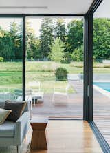 The aluminum sliding glass door system, manufactured by Solar Innovations, comprises five seamless panels that meet at the corner.